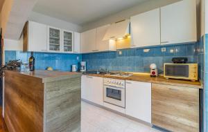 a kitchen with white cabinets and a microwave at Apartment Fucane Iv in Medulin
