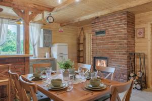 a dining room with a wooden table and a fireplace at Agroturystyka na Cisowym in Cisowe