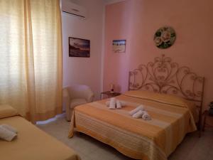 een slaapkamer met 2 bedden en handdoeken bij Scilla A Vinedda in Scilla