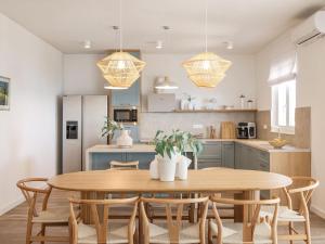 eine Küche und ein Esszimmer mit einem Holztisch und Stühlen in der Unterkunft Villa Grota by Interhome in Maslenica