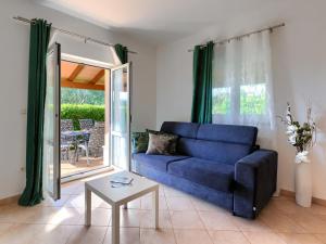 a living room with a blue couch and a table at Apartment Mir by Interhome in Vošteni
