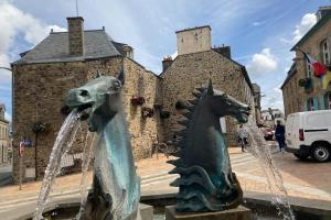 a fountain with two horses in front of a building at Brise Marine in Erquy +22 photos