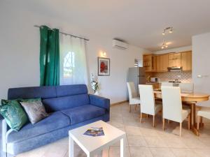 a living room with a blue couch and a table at Apartment Mir by Interhome in Vošteni