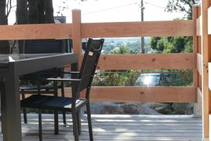 a black chair sitting at a table on a deck at Au pied des rochers in Erquy
