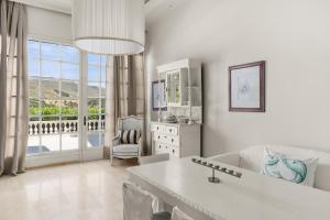 a white living room with a couch and a table at Paradise Art Hotel by Mr and Mrs White in Andros +19 photos