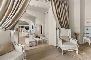 a living room with two white chairs and a couch at Paradise Art Hotel by Mr and Mrs White in Andros