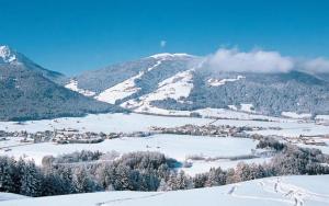 eine Stadt im Schnee mit einem Berg im Hintergrund in der Unterkunft Oberhölzlhof in Oberolang