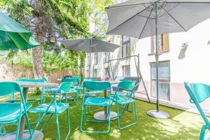 un gruppo di sedie e tavoli con ombrelloni di Convenient Shared Apartment - near Danube & Millenium Tower a Vienna