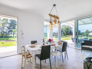 a dining room with a white table and chairs at Holiday Home Veronica by Interhome in Cecina