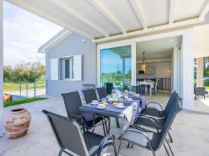 a dining room with blue tables and chairs on a patio at Holiday Home Veronica by Interhome in Cecina