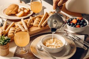a table with a breakfast table set with food and drinks at Paradise Art Hotel by Mr and Mrs White in Andros