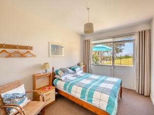 a bedroom with a bed and a window at Beach View Cottage in Felixstowe
