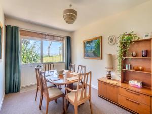 a dining room with a table and chairs and a window at Beach View Cottage in Felixstowe
