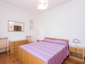 Un dormitorio con una cama y dos mesas y un espejo. en Apartment Giuliana by Interhome, en Torvaianica