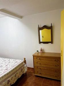 a bedroom with a bed and a dresser with a mirror at Cila's Guest House 1 in Praia da Vieira
