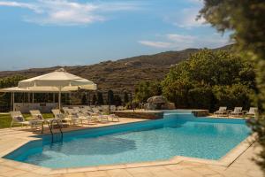 a swimming pool with chairs and an umbrella at Paradise Art Hotel in Andros