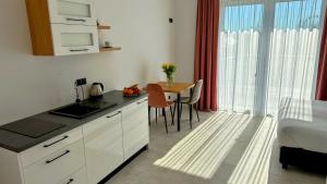 a kitchen with a table and a bed in a room at Bursztynowa Rosa & Wypożyczalnia rowerów elektrycznych in Łeba