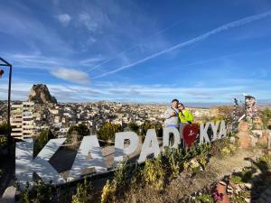 - un couple debout au sommet du panneau du parc Forza dans l'établissement Cappadocia Fairy Tale Suites, à Gorëme