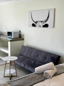 a living room with a couch and a picture of a cow at Rosetta Fields Country Lodge in Rosetta