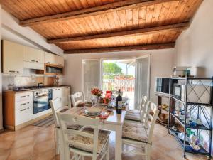 a dining room with a table and chairs and a kitchen at Apartment MareLuna by Interhome in Fontane Bianche
