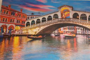 eine Brücke über einen Fluss mit Booten im Wasser in der Unterkunft Hotel Cristallo in Lido di Venezia