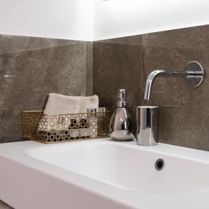 a bathroom sink with a faucet on top of it at La Duca Suites & Apartments in Palermo