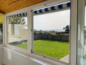 a window with a view of a yard at BAIE COTTAGE - Jardin aperçu baie, Wifi - D189 in Plouharnel +4 photos