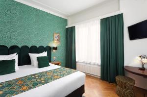 1 dormitorio con cama y pared verde en Hotel des Arts en Ámsterdam
