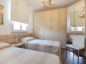 a bedroom with two beds and a chandelier at Holiday Home Fiumetto by Interhome in Marina di Pietrasanta