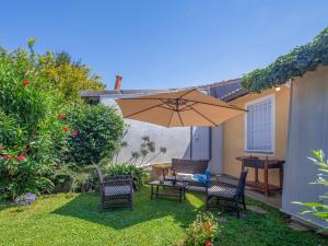 a patio with a table and chairs and an umbrella at Holiday Home Fiumetto by Interhome in Marina di Pietrasanta
