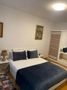 ein Schlafzimmer mit einem großen Bett mit blauen Kissen in der Unterkunft Prishtina Central Apartment in Pristina