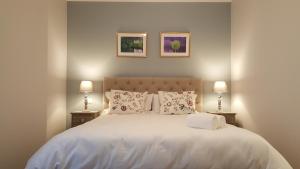 a bedroom with a large white bed with two lamps at Chez Jacqueline in Tours