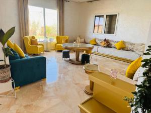 - un salon avec un canapé, une table et des chaises dans l'établissement Peaceful Pool Villa, à Marrakech
