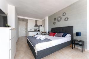 a bedroom with a large bed and a kitchen at CT 301 - Faro's Fuengirola Centro Studio in Fuengirola