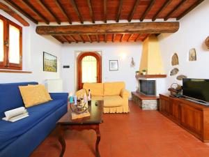 a living room with a blue couch and a tv at Apartment Le Mura by Interhome in Podere Panzano