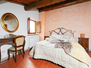a bedroom with a bed and a desk and a mirror at Apartment Le Mura by Interhome in Podere Panzano