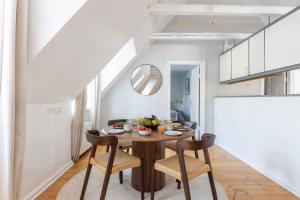 een eetkamer met een houten tafel en stoelen bij Unique Apartment w Exposed Beams Next to Tivoli in Kopenhagen