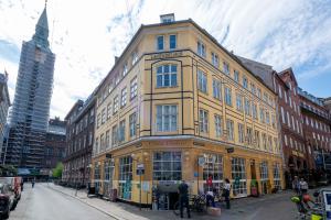 een groot geel gebouw in een stadsstraat bij Unique Apartment w Exposed Beams Next to Tivoli in Kopenhagen