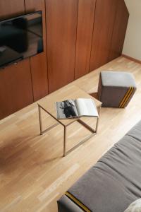 a living room with a coffee table with a book on it at Amberton Green Apartments Palanga in Palanga