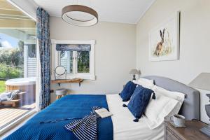 Un dormitorio con una cama con almohadas azules y blancas. en Rafters Lodge, Nr Saunton, en Georgeham