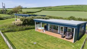 una vista aérea de una casa pequeña en un campo en Rafters Lodge, Nr Saunton, en Georgeham