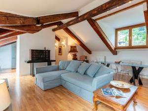 a living room with a blue couch and a table at Apartment Villa Ceriana-4 by Interhome in Ghiffa +32 photos