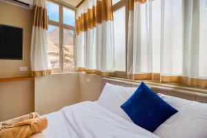 开罗Villa Khufu Pyramids Hotel的一间卧室配有一张带蓝色枕头的床和窗户 更多37张照片