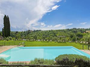 a large blue swimming pool in a green field at Apartment La Loggia by Interhome in Grassina +31 photos