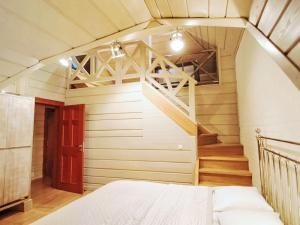 a room with a bed and a stair case at Holiday Home Drewniany z bala-2 by Interhome in Dębki