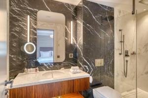 W łazience znajduje się umywalka, lustro i toaleta. w obiekcie Grand Hotel des Bains Kempinski w Sankt Moritz
