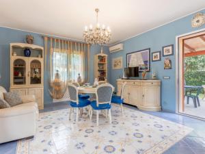 a dining room with blue walls and a table and chairs at Villa Olivella by Interhome in Lascari