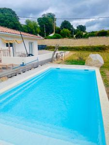 uma grande piscina azul em frente a uma casa em Casa Felicita em Bastelicaccia