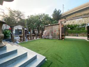 un cortile con prato verde e passeggino di Hotel Lagoona and Banquet Hall a Nuova Delhi