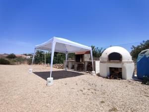 Tienda blanca con horno de pizza en un campo en Casa Rural Villa Arizona en Cartagena en Murcia